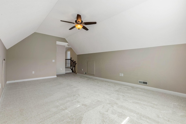 additional living space featuring visible vents, baseboards, light colored carpet, lofted ceiling, and ceiling fan