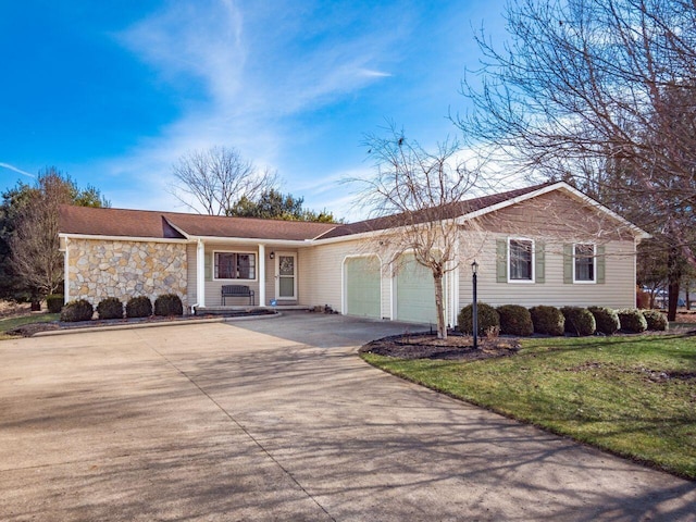 single story home with a garage, stone siding, a front lawn, and concrete driveway