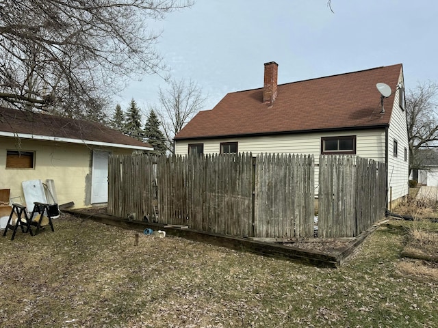 exterior space with a chimney and fence