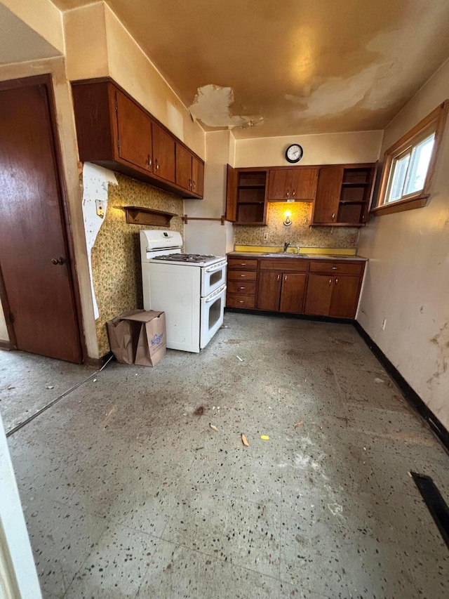 kitchen with open shelves, brown cabinets, range with two ovens, and a sink