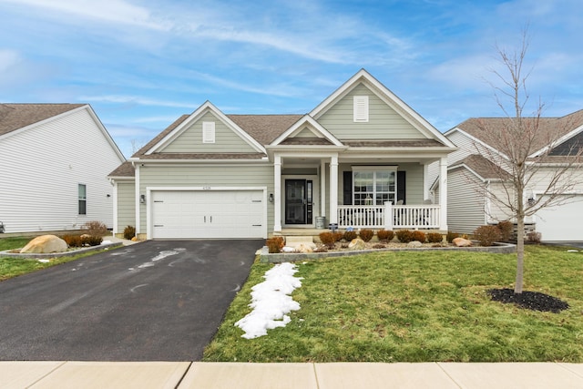 view of front facade featuring a garage, aphalt driveway, a front lawn, and a porch