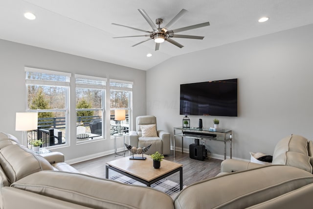 living room featuring vaulted ceiling, wood finished floors, a ceiling fan, and baseboards