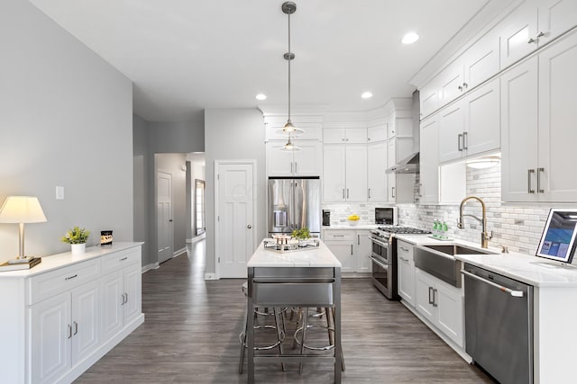 kitchen with white cabinets, a kitchen island, hanging light fixtures, stainless steel appliances, and a sink