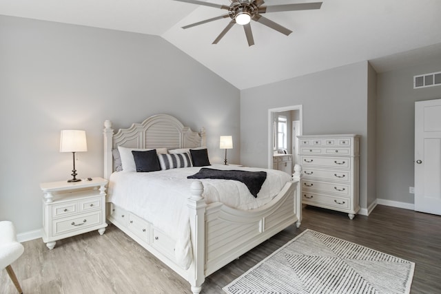 bedroom featuring baseboards, visible vents, vaulted ceiling, and wood finished floors