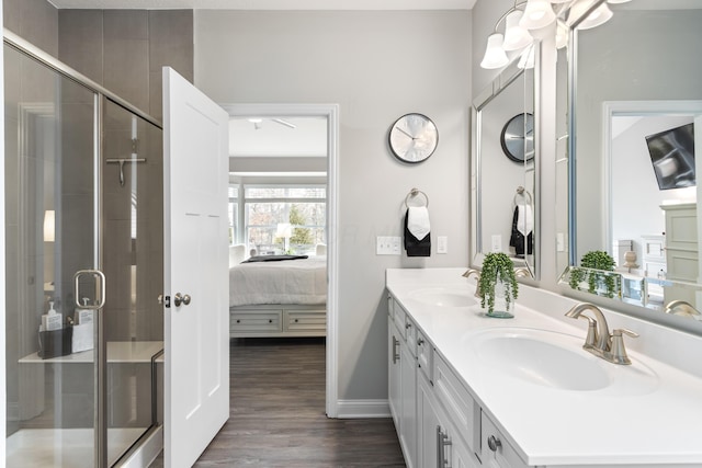 full bathroom with ensuite bath, wood finished floors, a sink, and a shower stall