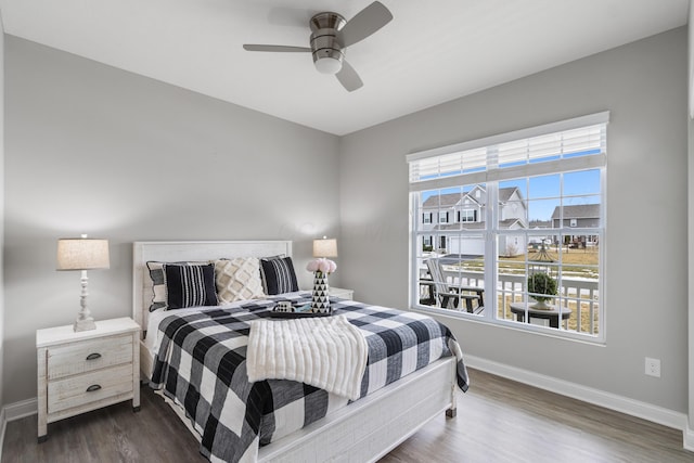 bedroom featuring baseboards, dark wood finished floors, and a ceiling fan