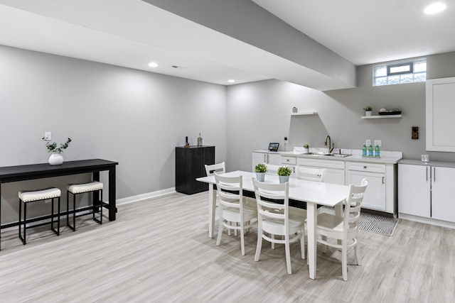 dining area featuring light wood finished floors, baseboards, and recessed lighting