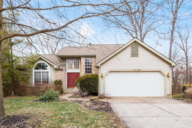 traditional-style house with a garage, driveway, roof with shingles, and brick siding