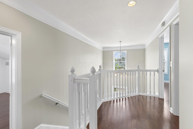 hallway with baseboards, ornamental molding, and an upstairs landing