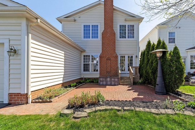 back of house featuring a chimney, a patio, and french doors
