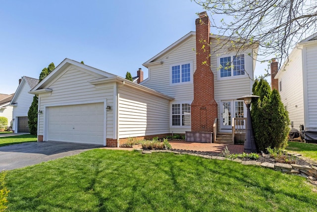 traditional-style home featuring a front yard, driveway, an attached garage, and a chimney