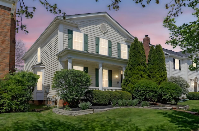 neoclassical home with a porch and a front yard