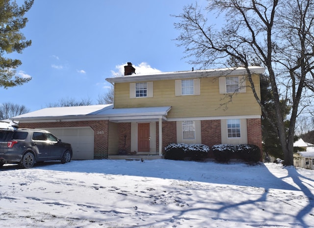 view of front facade with brick siding, a chimney, and an attached garage