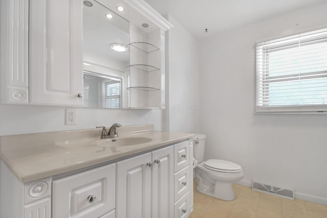 bathroom with toilet, baseboards, visible vents, and vanity