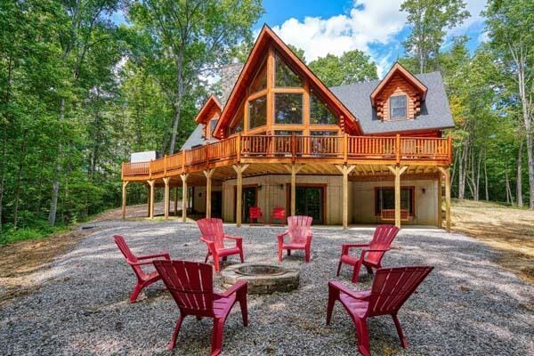 back of house with a fire pit and a deck