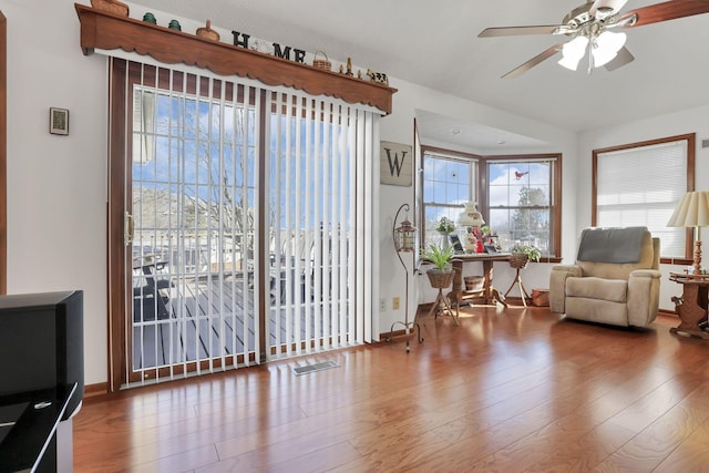 living area featuring visible vents, ceiling fan, and wood finished floors