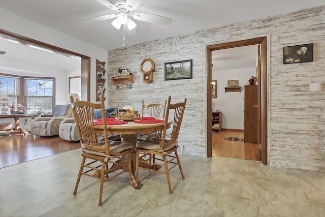 dining space with ceiling fan and wood finished floors