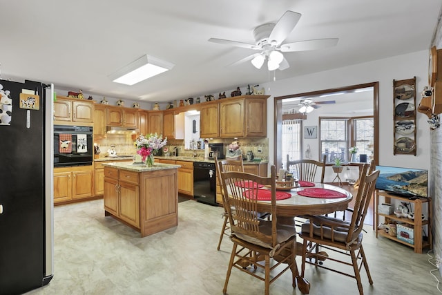 kitchen featuring backsplash, brown cabinetry, a kitchen island, under cabinet range hood, and black appliances