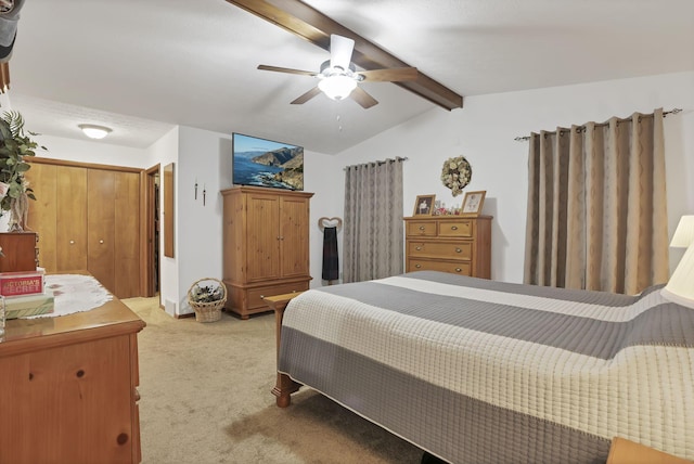 bedroom featuring a closet, light colored carpet, ceiling fan, and lofted ceiling with beams