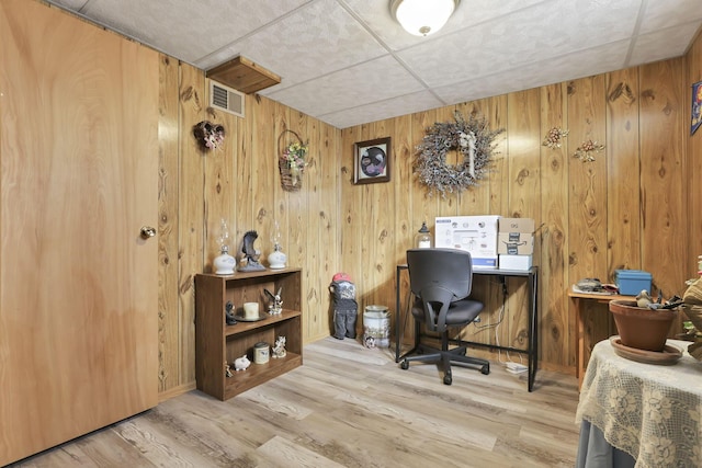 office with wooden walls, visible vents, and light wood-style flooring