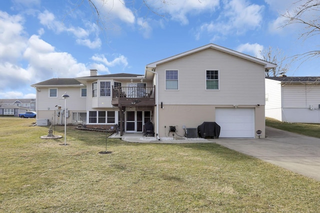 back of property with a balcony, central air condition unit, a garage, concrete driveway, and a lawn