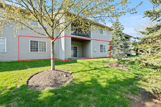 rear view of property with a balcony and a yard