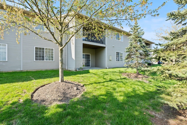 back of house with a balcony and a yard