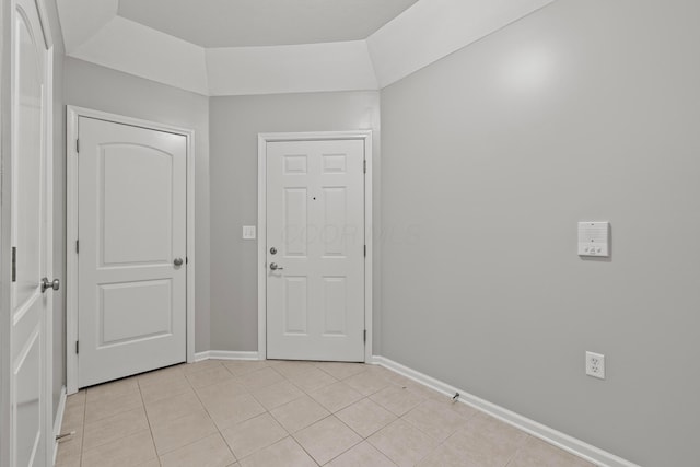 foyer featuring light tile patterned flooring and baseboards