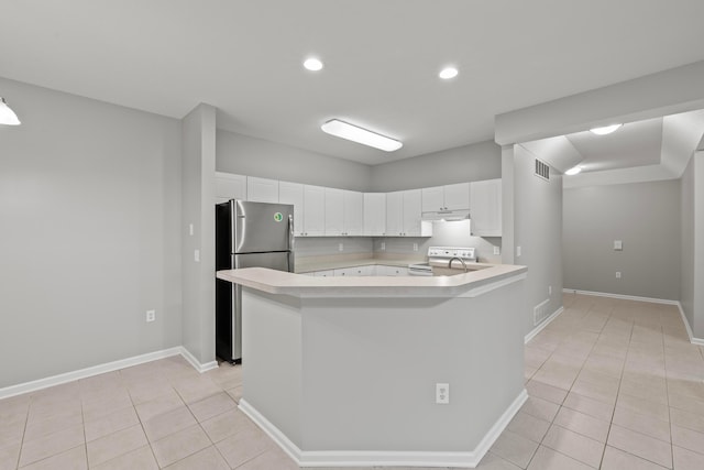 kitchen featuring light tile patterned floors, light countertops, visible vents, and freestanding refrigerator