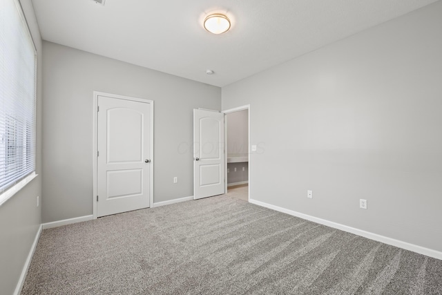 unfurnished bedroom featuring carpet floors and baseboards