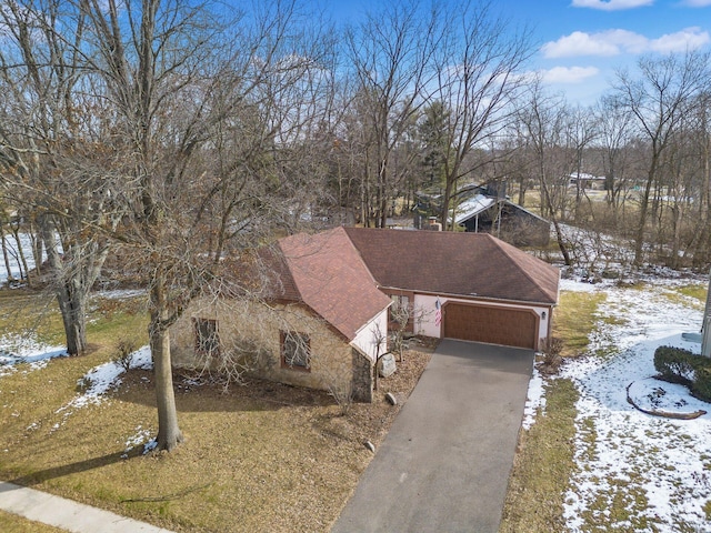 view of front of home with an attached garage, driveway, and a shingled roof