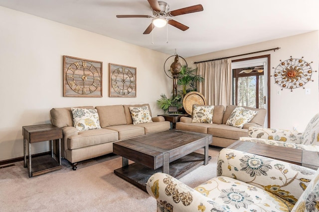 living area with visible vents, baseboards, a ceiling fan, and light colored carpet