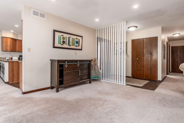 interior space featuring recessed lighting, visible vents, a sink, and baseboards