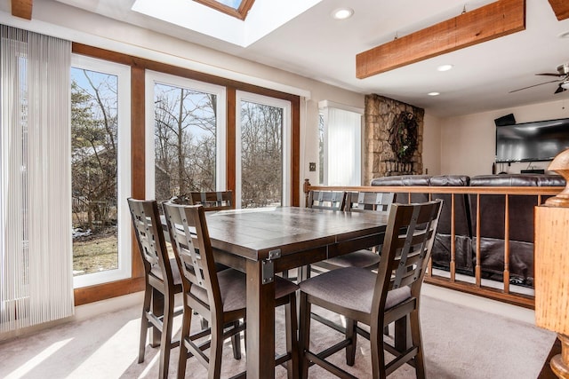 dining room featuring recessed lighting, a skylight, and light colored carpet