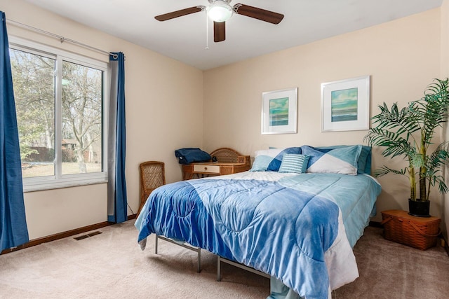 carpeted bedroom with baseboards, visible vents, and ceiling fan