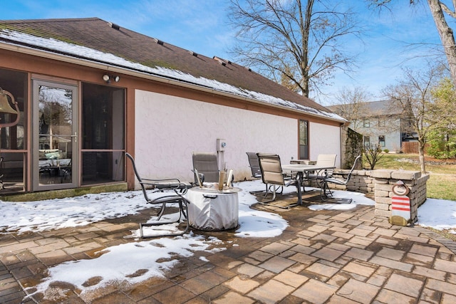 snow covered patio with outdoor dining space