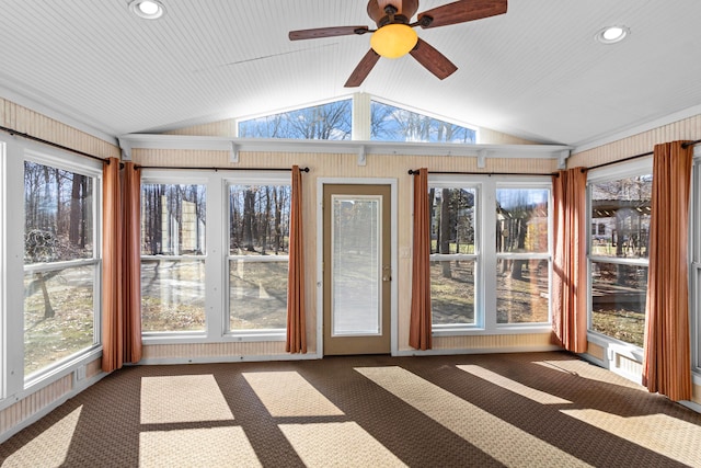 unfurnished sunroom featuring lofted ceiling, a ceiling fan, and a healthy amount of sunlight