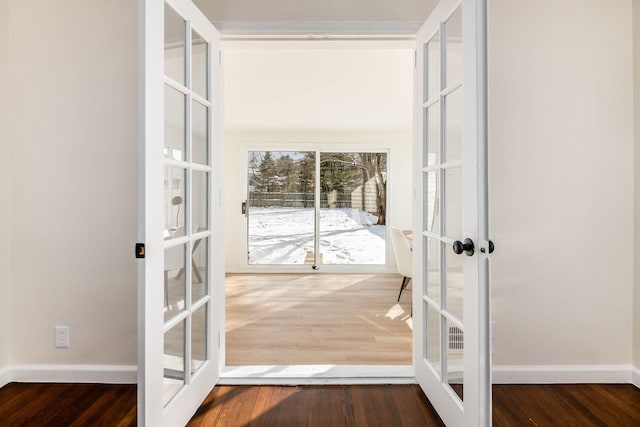 doorway with french doors, wood finished floors, and baseboards