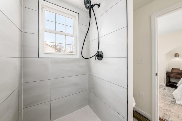 bathroom featuring baseboards and a tile shower