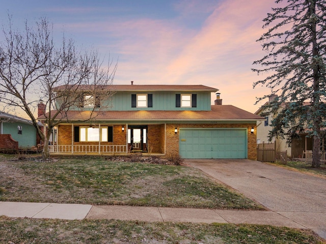 traditional-style house with a porch, brick siding, driveway, and fence