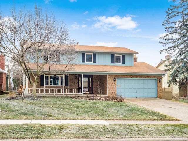 traditional home with brick siding, a porch, fence, driveway, and a front lawn