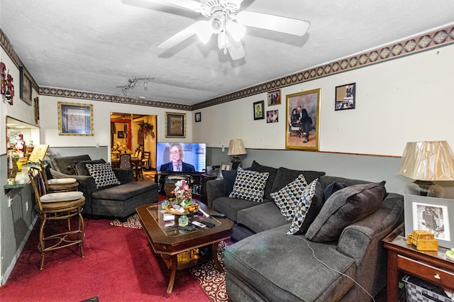 living room featuring a textured ceiling, carpet floors, and ceiling fan