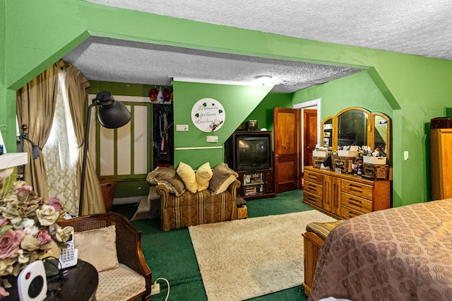 bedroom featuring a textured ceiling and dark carpet