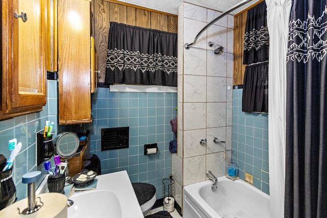 full bath with toilet, a textured ceiling, and shower / bath combination with curtain