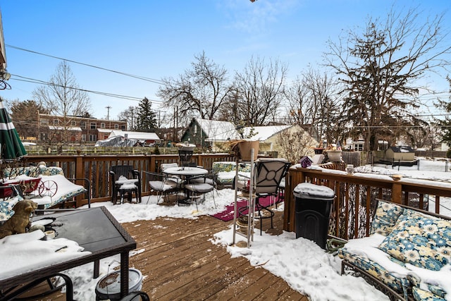 snow covered deck with a residential view and outdoor dining space