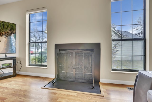 details with a fireplace, baseboards, and wood finished floors