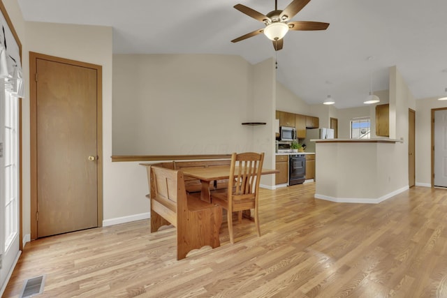 dining space with light wood-type flooring, visible vents, vaulted ceiling, and baseboards