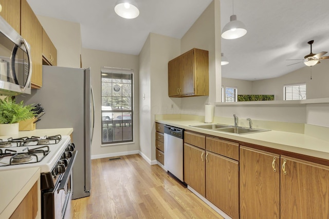 kitchen with a wealth of natural light, stainless steel appliances, a sink, and brown cabinetry