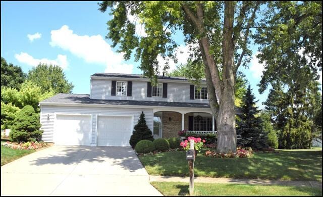 traditional-style home with concrete driveway and a front yard