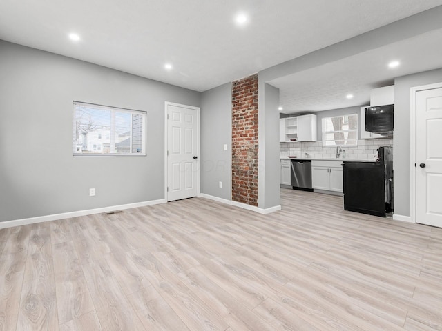 unfurnished living room featuring recessed lighting, a sink, visible vents, baseboards, and light wood finished floors